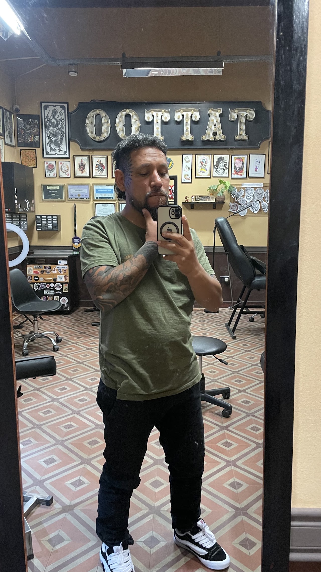 Walter frente a la pared de flash art del estudio Walterink Tattoos